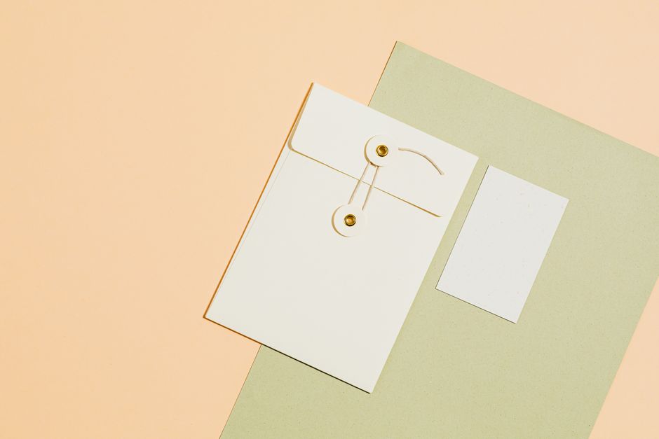 Elegant flat lay of envelopes and paper on yellow background, perfect for office or creative use.